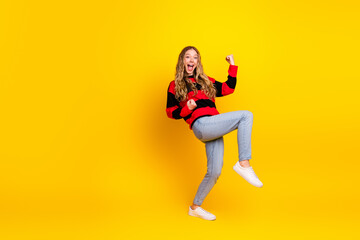 Joyful young woman in casual knitwear, cheerfully expressing herself against a vibrant yellow...
