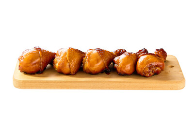 Obraz premium Grilled chicken drumsticks on a cutting board isolated. Fried crispy chicken legs on a cutting board isolated.