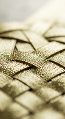 Detailed close-up of interweaved golden ribbon, creating textured surface, represents texture, pattern, construction, and shine, perfect for elegance and craft concepts