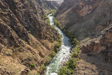 A stormy stream of a mountain river flows inside the Black canyon located in Kazakhstan