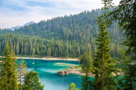 View of Cauma Lake Caumasee with crystal blue turquoise water and rocky beach in beautiful mountain landscape with pine forest, Flims, Graubuenden, Switzerland.