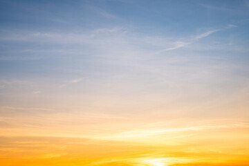 Obraz premium Sunset or sunrise sky with a vibrant gradient of orange, gold, and soft blue. Clear atmosphere with wispy clouds. Peaceful, natural light background. hope, freedom, new day and inspirational Concepts