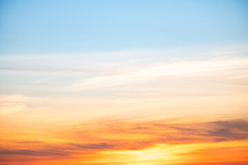 Fototapeta premium Sunset or sunrise sky with a vibrant gradient of orange, gold, and soft blue. Clear atmosphere with wispy clouds. Peaceful, natural light background. hope, freedom, new day and inspirational Concepts