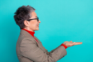 Senior businesswoman short stylish haircut checkered jacket and red turtleneck presenting open...