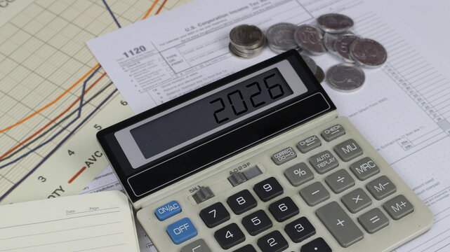 Tax planning concept with calculator displaying 2026, coins and corporate income tax form. Financial accounting, budgeting, audit, business taxation, economy, investment, office finance strategy