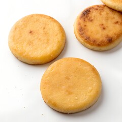 three round baked goods on a white surface one slightly burnt white background.