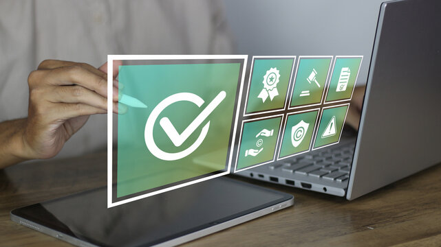 Business professional approving digital compliance checklist with certification, copyright, and security icons on virtual interface using laptop and tablet, representing legal standards