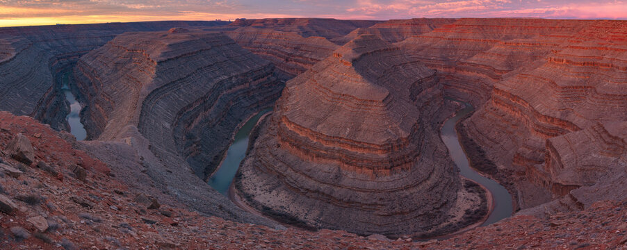 This colorful desert canyon panorama at dawn of Goosenecks State Park features the entrenched river meander of the San Juan River.