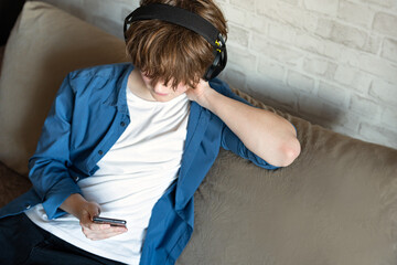 Young man with smartphone and headphones listening to something