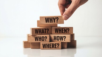 Hand placing wooden block with why question on top of pyramid made of blocks with what when who how and where questions
