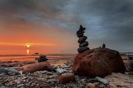 Stack of stones on a sandy beach by the Baltic Sea at sunset, Lithuania