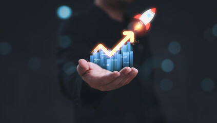 Obraz premium Businessman holding financial graph with upward arrow and rocket representing stock market profit dividend success for good trading performance and business investment growth strategy concept.