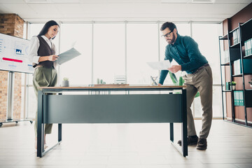 Business professionals review documents at a modern office during planning at a large desk