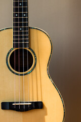 Obraz premium Front view of acoustic guitar with wooden texture and neutral background