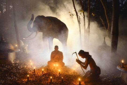 Buddhist Monk and Muay Thai boxer Meditating in the Forest with an elephant in the background, Krapho, Tha Tum District, Surin, Thailand