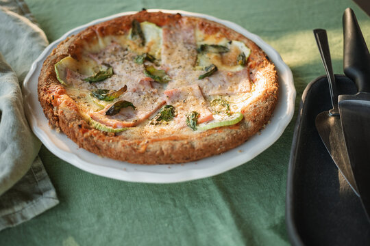 Close-up of a homemade gluten free low carb ham, courgette and mozzarella pizza with an almond flour base