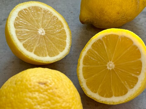 Close-up of fresh lemons and a halved lemon on a kitchen counter