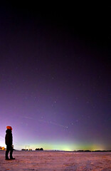 Fototapeta premium A woman looking at Northern lights aurora borealis and meteor Sweden 11.01.2026