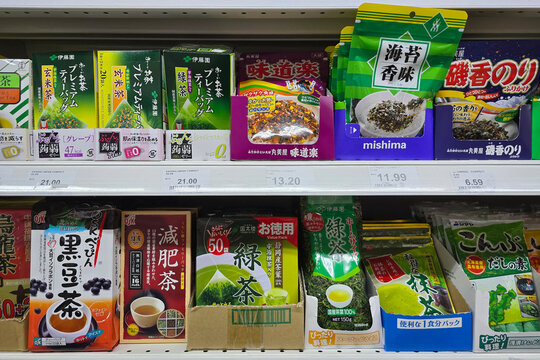 Penang, Malaysia: Nov 06, 2025: Various Japanese food products including green tea, barley tea, roasted seaweed, and furikake seasoning packets displayed on supermarket shelves.