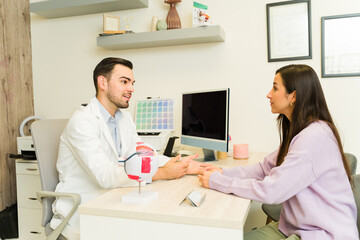 Obraz premium Medical professional explaining vision care to patient using eye model during consultation for medical exam