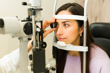 Fototapeta na wymiar Ophthalmologist examining woman's eye with slit lamp for vision care and medical checkup appointment