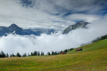 Winding gravel hiking path on Mount Penken near Mayrhofen, offering panoramic views of the Zillertal Alps under a dramatic cloudy sky, Tyrol, Austria.