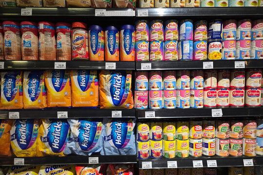 Penang, Malaysia: Nov 06, 2025: Fully stocked shelves in a supermarket aisle displaying various powdered and canned beverage products include Horlicks, Nestle Coffee-Mate, F&N, Marigold and Carnation.