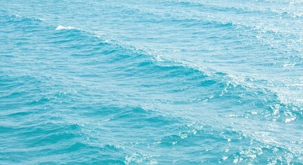 Rippled turquoise sea with sunlight glittering off small waves, abstract