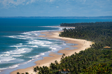 Golden hour view of a peaceful tropical beach in Bahia, Brazil, featuring textured wet sand,...