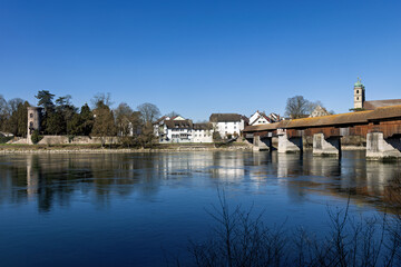Fototapeta premium Bad Saeckingen across the Rhine with its old, historic wooden bridge and St. Fridolin's Minster in spring