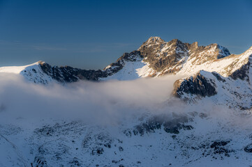 Winter panorama of High Tatra mountains with Swinica peak and Dolina Pieciu Stawow Polskich, covered in snow in late afternoon sunlight