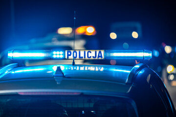 Policyjny radiowóz z reflektorem w nocy na ulicy