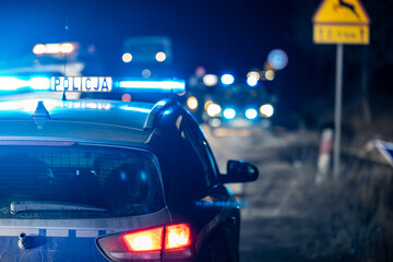 Policyjny radiowóz z reflektorem w nocy na ulicy