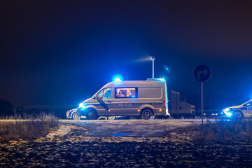 Policyjny radiowóz z reflektorem w nocy na ulicy © FotoDax