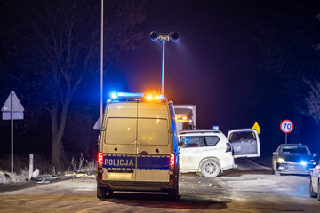 Policyjny radiowóz z reflektorem w nocy na ulicy