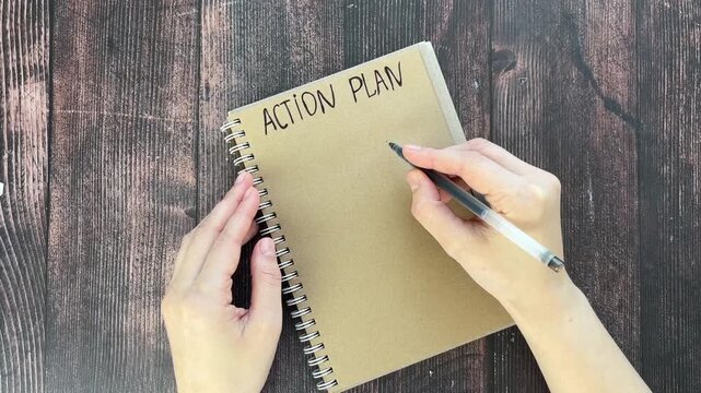Writing an action plan on notebook with pen. 