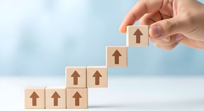 Hand arranging wooden blocks with upward arrows