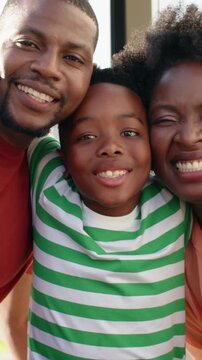 Vertical video: Raising arms boy in striped tee drawing parents close at door for portrait