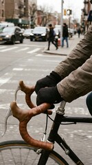 Obraz premium The image encapsulates the dynamic energy of urban cycling, offering a close-up perspective of the handlebars and gloved hands of a cyclist navigating a bustling city street.