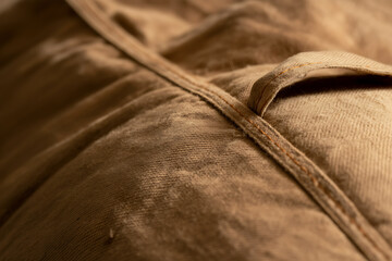 Naklejka premium Extreme close-up of textured beige fabric with visible stitching and a soft, wavy surface