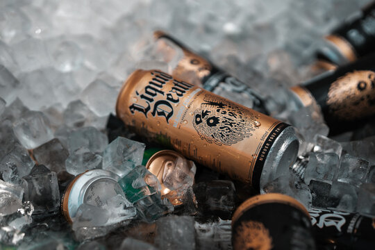 Liquid Death drinks can on ice, branded water beverage in a gold can