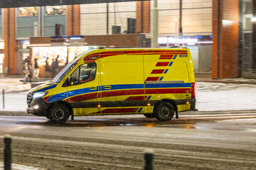 Karetka medyczna w śniegu zimą na sygnale alarmowo © FotoDax