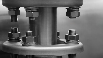 Close-up of two pipes connected with bolts and nuts. Concept of complexity and intricacy....