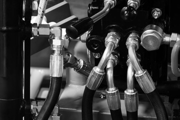 Electrical wires and hydraulic hoses are connected to a large industrial production machine...