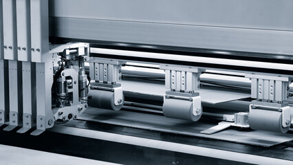 Cardboard box templates are lined up on conveyor of  automated industrial packaging machine, ready to be opened and filled with food products.