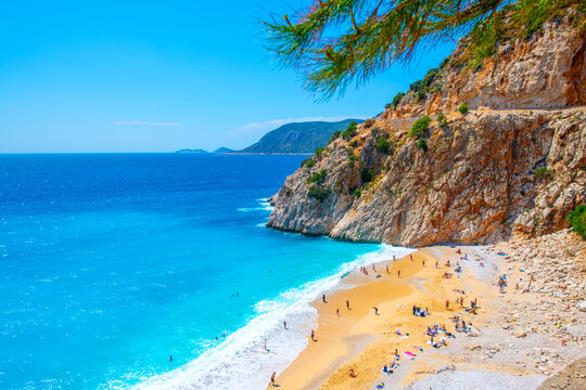 The famous "Kaputas Beach". Excellent nature and sea. People entering the sea and the beach. Beach umbrellas and sun beds. View of the beach from above. Kas region, Antalya, Turkey. 