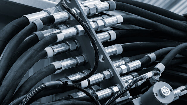 Bundle of pipes connected to industrial hydraulic pneumatic machine, industrial concept