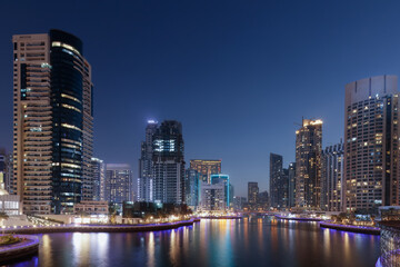 Urban identity of the Emirates with illuminated residential towers lining the marina water and layered night panorama. For Global city branding and skyline visuals  © Nimbus Works