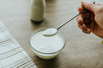 Close-up of male hand scooping yogurt from a bowl