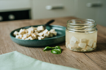 Tofu in a jar and in a plate on a wooden table